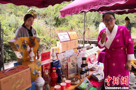 图为甘肃甘南州乡村旅游渐热，当地人向游客推荐土特产。　刘玉桃 摄